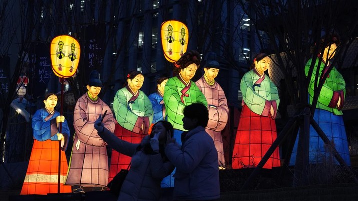 Sepasang kekasih berswafoto dengan lentera bercahaya selama Festival Lentera di Lapangan Gwanghwamun di Seoul, Korea Selatan, Senin, 19 Desember 2022. Festival ini akan berlangsung dari 19 Desember hingga 31 Desember. (AP Photo/Ahn Young-joon)
