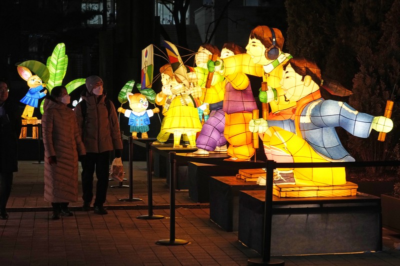 Seorang pengunjung mengambil foto lentera raksasa yang bersinar untuk perayaan Tahun Kelinci 2023 mendatang selama Festival Lentera di Lapangan Gwanghwamun di Seoul, Korea Selatan, Senin, 19 Desember 2022. Festival ini akan berlangsung dari 19 Desember hingga Desember 31. (AP Photo/Ahn Young-joon)