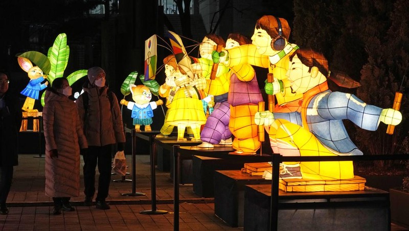 Seorang pengunjung mengambil foto lentera raksasa yang bersinar untuk perayaan Tahun Kelinci 2023 mendatang selama Festival Lentera di Lapangan Gwanghwamun di Seoul, Korea Selatan, Senin, 19 Desember 2022. Festival ini akan berlangsung dari 19 Desember hingga Desember 31. (AP Photo/Ahn Young-joon)