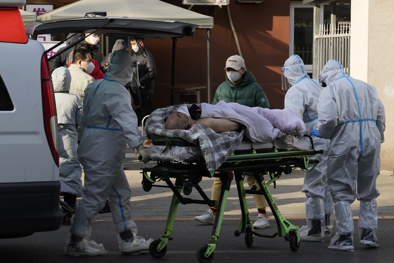 Seorang pasien didorong ke klinik demam di sebuah rumah sakit di Beijing, China, Senin (19/12/2022). China diprediksi bakal mengalami lonjakan kematian akibat Covid-19 hingga lebih dari satu juta kasus pada 2023 jika tren penularan virus corona terus melonjak. (AP Photo/Andy Wong)