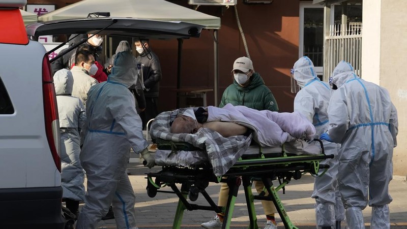 Seorang pasien didorong ke klinik demam di sebuah rumah sakit di Beijing, China, Senin (19/12/2022). China diprediksi bakal mengalami lonjakan kematian akibat Covid-19 hingga lebih dari satu juta kasus pada 2023 jika tren penularan virus corona terus melonjak. (AP Photo/Andy Wong)