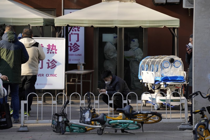 Seorang pasien didorong ke klinik demam di sebuah rumah sakit di Beijing, China, Senin (19/12/2022). China diprediksi bakal mengalami lonjakan kematian akibat Covid-19 hingga lebih dari satu juta kasus pada 2023 jika tren penularan virus corona terus melonjak. (AP Photo/Andy Wong)