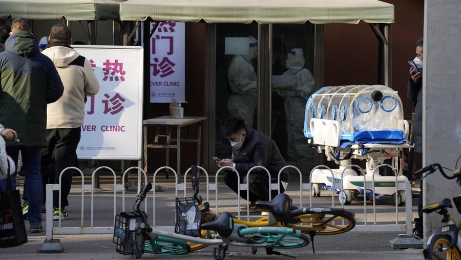 Seorang pasien didorong ke klinik demam di sebuah rumah sakit di Beijing, China, Senin (19/12/2022). China diprediksi bakal mengalami lonjakan kematian akibat Covid-19 hingga lebih dari satu juta kasus pada 2023 jika tren penularan virus corona terus melonjak. (AP Photo/Andy Wong)