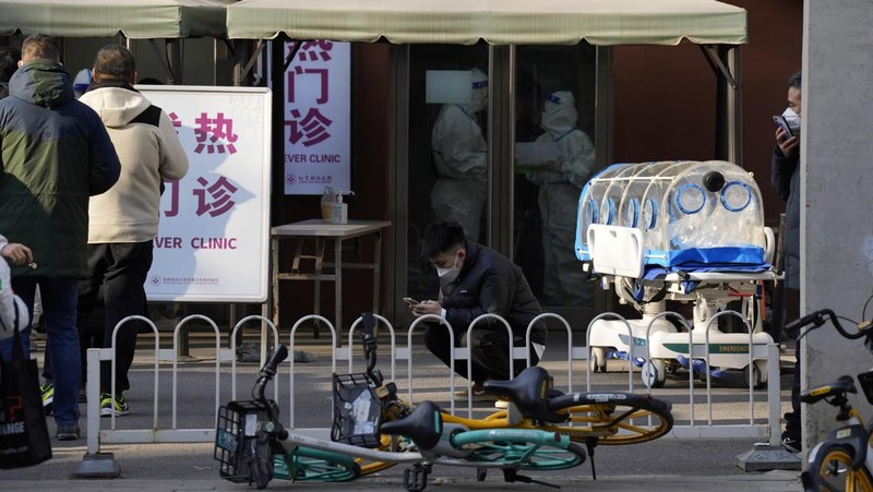 Seorang pasien didorong ke klinik demam di sebuah rumah sakit di Beijing, China, Senin (19/12/2022). China diprediksi bakal mengalami lonjakan kematian akibat Covid-19 hingga lebih dari satu juta kasus pada 2023 jika tren penularan virus corona terus melonjak. (AP Photo/Andy Wong)