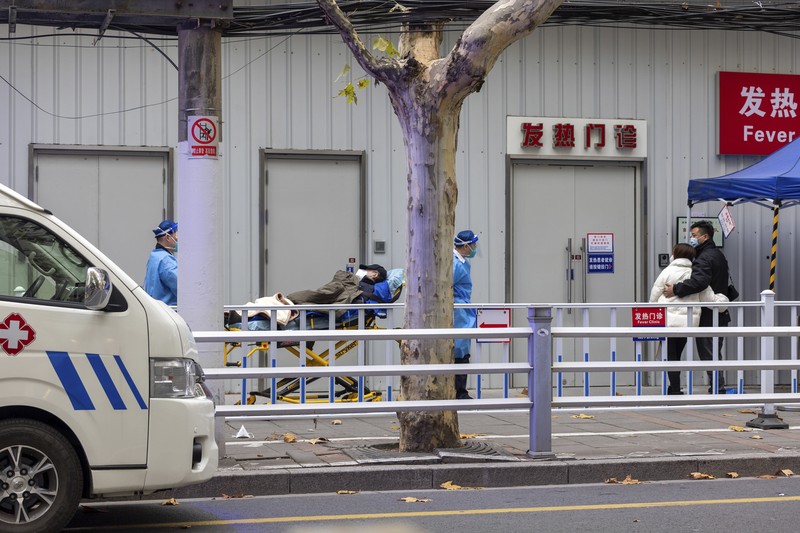 Seorang pasien didorong ke klinik demam di sebuah rumah sakit di Beijing, China, Senin (19/12/2022). China diprediksi bakal mengalami lonjakan kematian akibat Covid-19 hingga lebih dari satu juta kasus pada 2023 jika tren penularan virus corona terus melonjak. (AP Photo/Andy Wong)