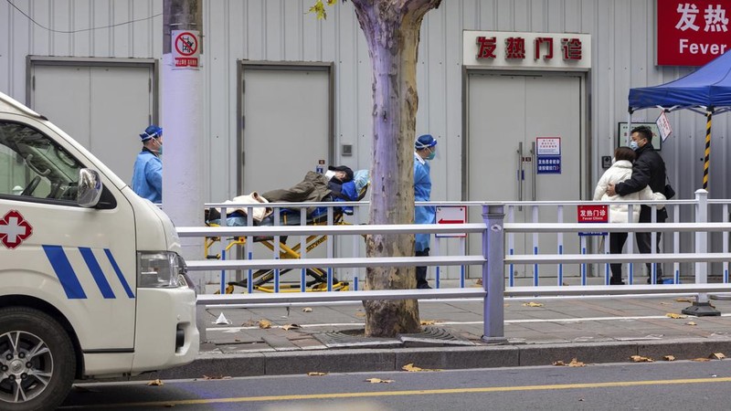 Seorang pasien didorong ke klinik demam di sebuah rumah sakit di Beijing, China, Senin (19/12/2022). China diprediksi bakal mengalami lonjakan kematian akibat Covid-19 hingga lebih dari satu juta kasus pada 2023 jika tren penularan virus corona terus melonjak. (AP Photo/Andy Wong)