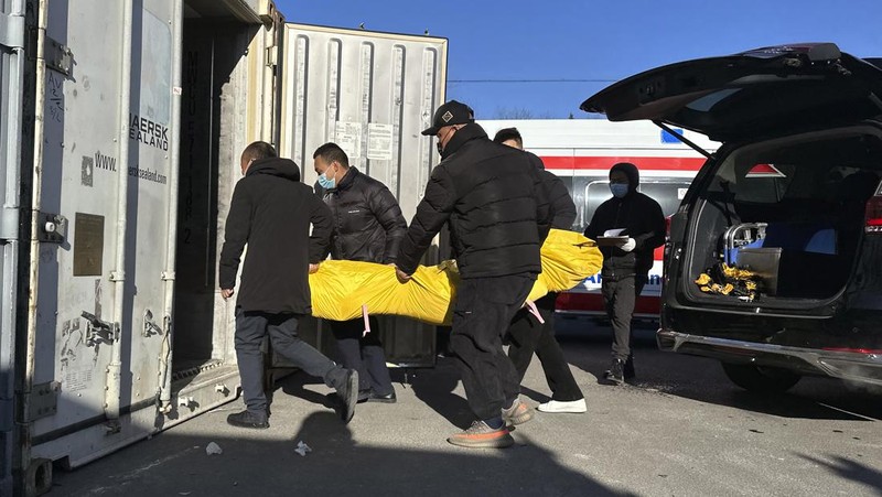 Seorang pasien didorong ke klinik demam di sebuah rumah sakit di Beijing, China, Senin (19/12/2022). China diprediksi bakal mengalami lonjakan kematian akibat Covid-19 hingga lebih dari satu juta kasus pada 2023 jika tren penularan virus corona terus melonjak. (AP Photo/Andy Wong)