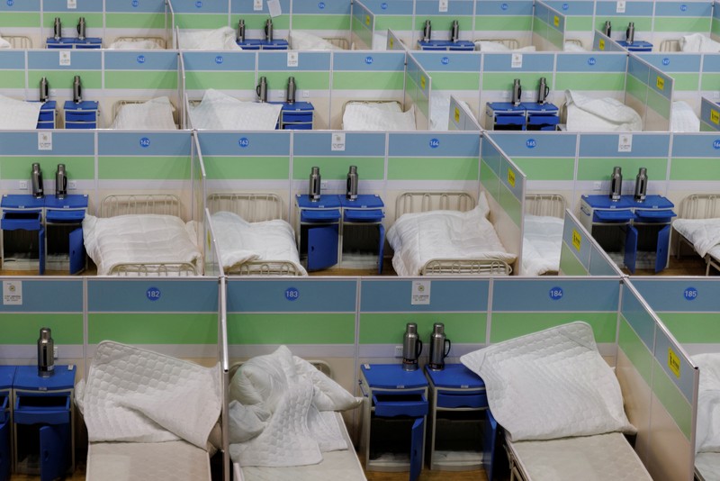 Pengemudi ambulans menurunkan pasien di luar klinik demam yang merawat pasien COVID-19 di Beijing, China, Rabu (21/12/2022). Kondisi pandemi Covid-19 di China terus memburuk seiring dengan berakhirnya kebijakan penguncian ketat di seluruh negeri. (Photo by Kevin Frayer/Getty Images)