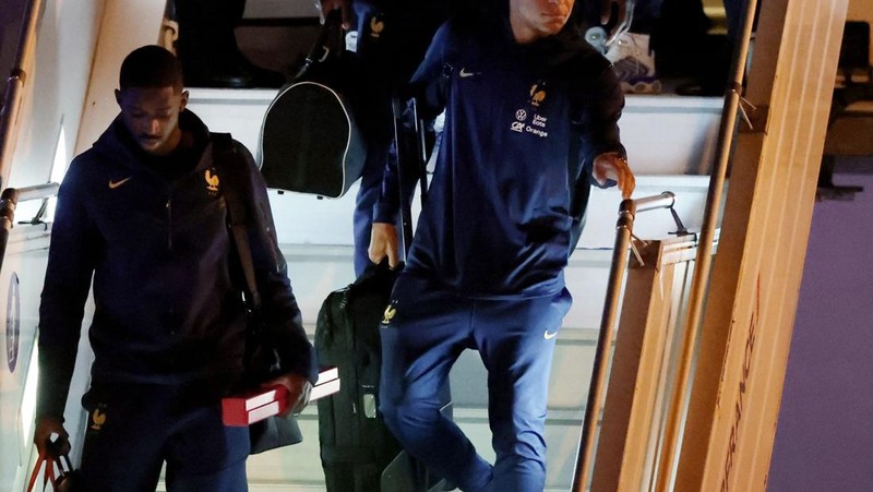 Penyerang Prancis Ousmane Dembele (Kiri) dan penyerang Kylian Mbappe (Kanan) keluar dari pesawat AirFrance saat tim nasional Prancis tiba di Bandara Paris Charles de Gaulle, Prancis, Senin (9/12/2022). Tim Prancis tiba di negaranya setelah mengikuti pertandingan final antara Prancis melawan Argentina dalam gelaran Piala Dunia 2022 Qatar dan disambut para pendukungnya meskipun harus kalah oleh Argentina dalam pertandingan final tersebut. (Photo by CHARLY TRIBALLEAU/AFP via Getty Images)