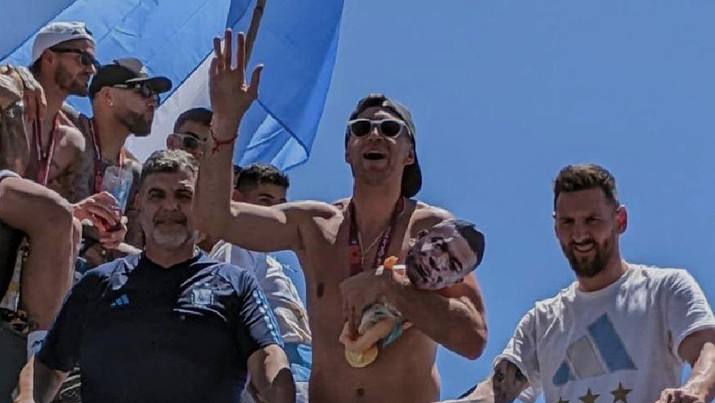 Emiliano Martínez mengangkat boneka bayi dengan wajah Kylian Mbappé saat parade trofi Argentina. ( Emiliano Martínez mengangkat boneka bayi dengan wajah Kylian Mbappé saat parade trofi Argentina. (Tangkapan layar : Kredit foto: Optus Sport via twitter @OptusSport)
