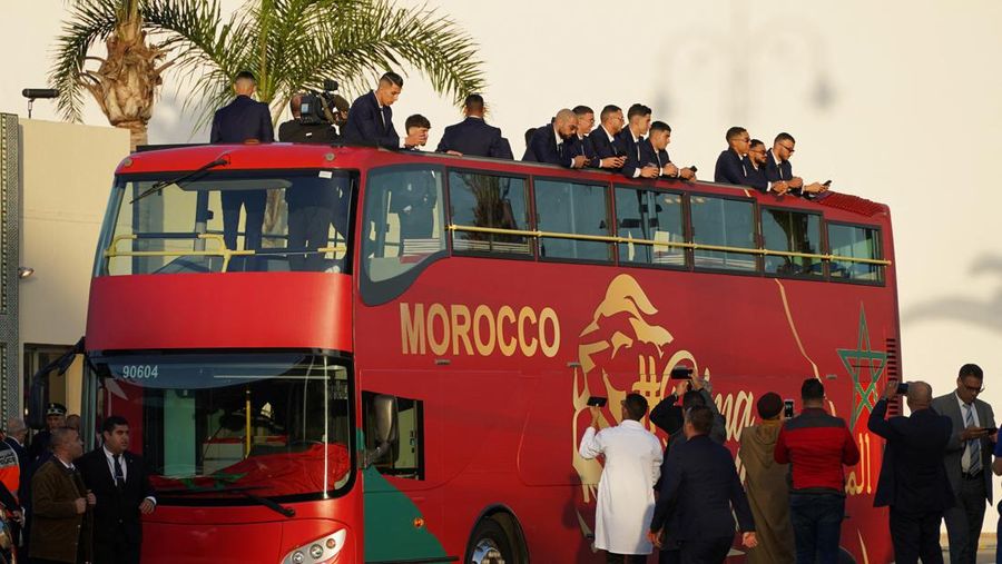 Pendukung bersorak dan menyalakan suar saat tim sepak bola nasional Maroko tiba di pusat ibu kota Rabat, pada 20 Desember 2022, setelah Piala Dunia Qatar 2022. (FADEL SENNA/AFP via Getty Images)
