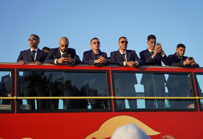 Pendukung bersorak dan menyalakan suar saat tim sepak bola nasional Maroko tiba di pusat ibu kota Rabat, pada 20 Desember 2022, setelah Piala Dunia Qatar 2022. (FADEL SENNA/AFP via Getty Images)