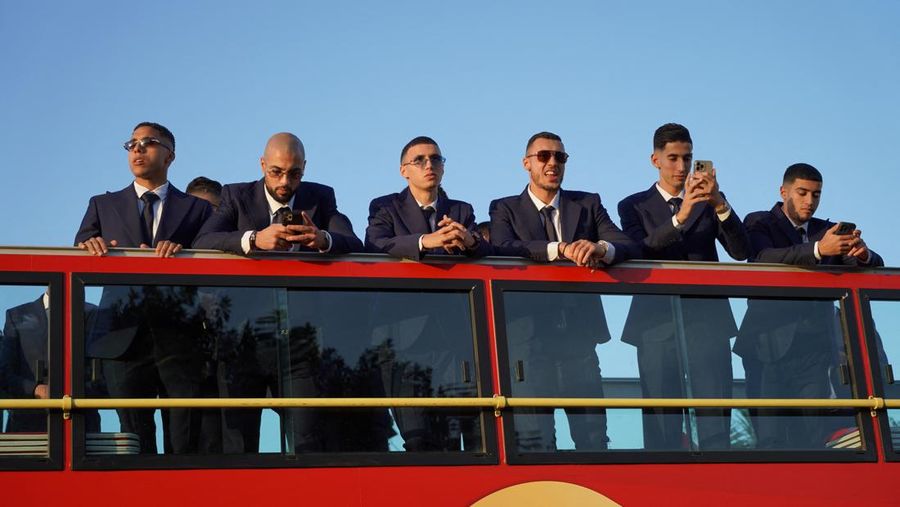 Pendukung bersorak dan menyalakan suar saat tim sepak bola nasional Maroko tiba di pusat ibu kota Rabat, pada 20 Desember 2022, setelah Piala Dunia Qatar 2022. (FADEL SENNA/AFP via Getty Images)