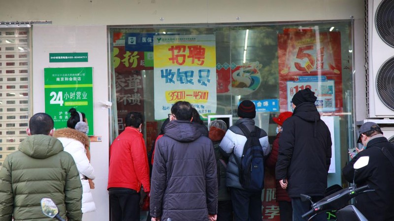 Pengemudi ambulans menurunkan pasien di luar klinik demam yang merawat pasien COVID-19 di Beijing, China, Rabu (21/12/2022). Kondisi pandemi Covid-19 di China terus memburuk seiring dengan berakhirnya kebijakan penguncian ketat di seluruh negeri. (Photo by Kevin Frayer/Getty Images)