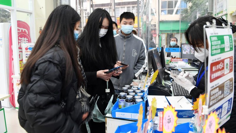Pengemudi ambulans menurunkan pasien di luar klinik demam yang merawat pasien COVID-19 di Beijing, China, Rabu (21/12/2022). Kondisi pandemi Covid-19 di China terus memburuk seiring dengan berakhirnya kebijakan penguncian ketat di seluruh negeri. (Photo by Kevin Frayer/Getty Images)