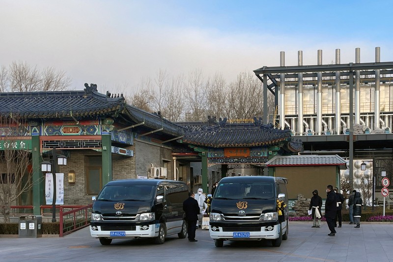 Pengemudi ambulans menurunkan pasien di luar klinik demam yang merawat pasien COVID-19 di Beijing, China, Rabu (21/12/2022). Kondisi pandemi Covid-19 di China terus memburuk seiring dengan berakhirnya kebijakan penguncian ketat di seluruh negeri. (Photo by Kevin Frayer/Getty Images)