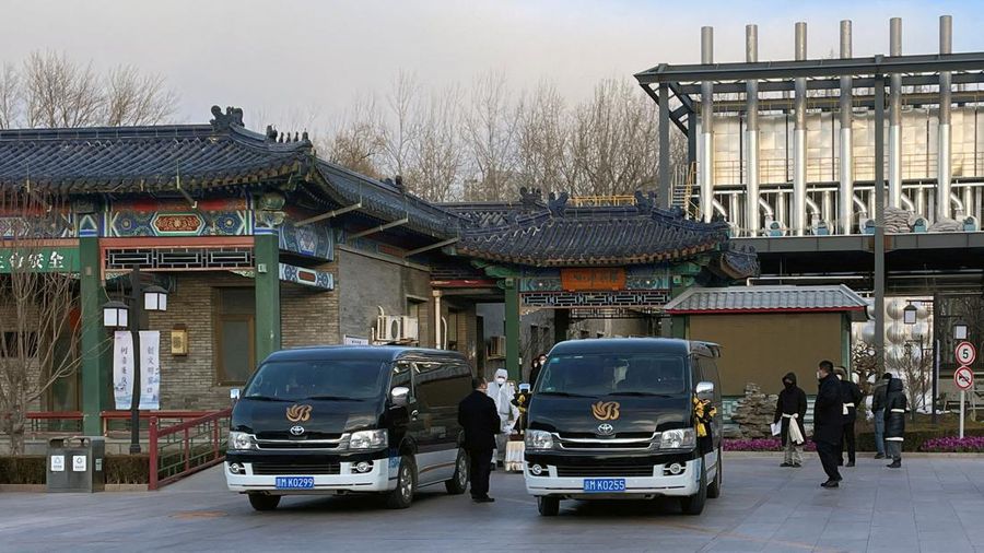 Pengemudi ambulans menurunkan pasien di luar klinik demam yang merawat pasien COVID-19 di Beijing, China, Rabu (21/12/2022). Kondisi pandemi Covid-19 di China terus memburuk seiring dengan berakhirnya kebijakan penguncian ketat di seluruh negeri. (Photo by Kevin Frayer/Getty Images)
