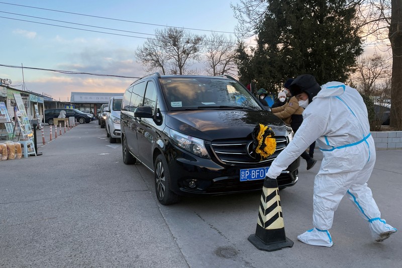 Kondisi pandemi Covid-19 di China Pengemudi ambulans menurunkan pasien di luar klinik demam yang merawat pasien COVID-19 di Beijing, China, Rabu (21/12/2022). Kondisi pandemi Covid-19 di China terus memburuk seiring dengan berakhirnya kebijakan penguncian ketat di seluruh negeri. (Photo by Kevin Frayer/Getty Images)