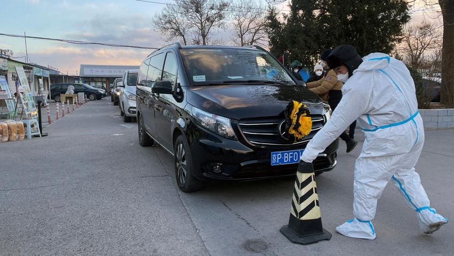 Pengemudi ambulans menurunkan pasien di luar klinik demam yang merawat pasien COVID-19 di Beijing, China, Rabu (21/12/2022). Kondisi pandemi Covid-19 di China terus memburuk seiring dengan berakhirnya kebijakan penguncian ketat di seluruh negeri. (Photo by Kevin Frayer/Getty Images)