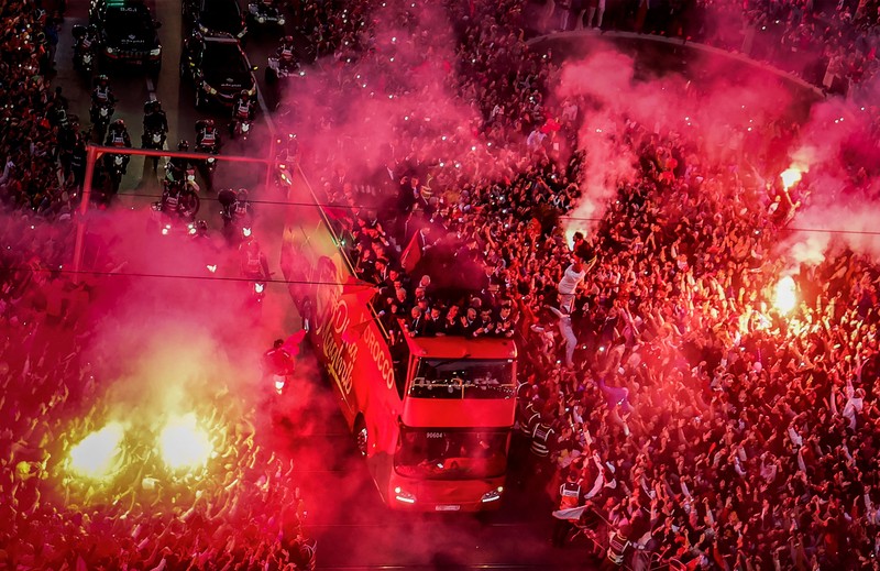 Pendukung bersorak dan menyalakan suar saat tim sepak bola nasional Maroko tiba di pusat ibu kota Rabat, pada 20 Desember 2022, setelah Piala Dunia Qatar 2022. (FADEL SENNA/AFP via Getty Images)