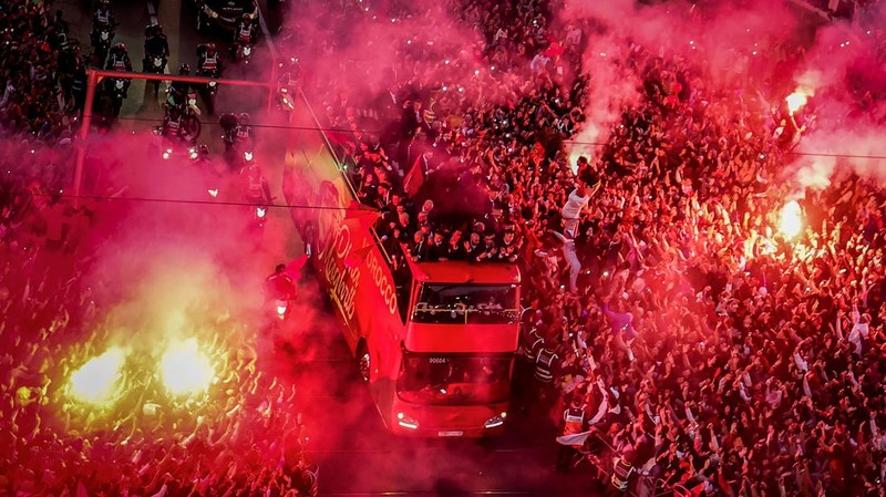 Pendukung bersorak dan menyalakan suar saat tim sepak bola nasional Maroko tiba di pusat ibu kota Rabat, pada 20 Desember 2022, setelah Piala Dunia Qatar 2022. (FADEL SENNA/AFP via Getty Images)