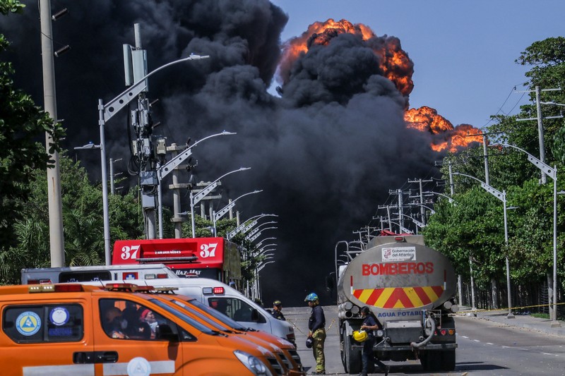 Asap hitam mengepul dari kebakaran di depot hidrokarbon di Barranquilla, Kolombia, pada 21 Desember 2022. Asap hitam mengepul dari kebakaran di depot hidrokarbon di Barranquilla, Kolombia, pada 21 Desember 2022. Pihak berwenang melaporkan kebakaran serius di kota Barranquilla, Kolombia, tampaknya menunjukkan sembilan mesin dari Dinas Pemadam Kebakaran yang melayani pemadam kebakaran. meledak di salah satu tangki penyimpanan. darurat dan pihak berwenang mengatakan bahwa keadaan darurat dapat memakan waktu antara dua dan tiga hari. (David Moran/Anadolu Agency via Getty Images)
