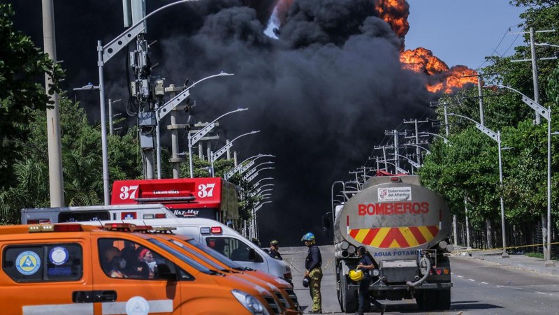 Asap hitam mengepul dari kebakaran di depot hidrokarbon di Barranquilla, Kolombia, pada 21 Desember 2022. Pihak berwenang melaporkan kebakaran serius di kota Barranquilla, Kolombia, tampaknya menunjukkan sembilan mesin dari Dinas Pemadam Kebakaran yang melayani pemadam kebakaran. meledak di salah satu tangki penyimpanan. darurat dan pihak berwenang mengatakan bahwa keadaan darurat dapat memakan waktu antara dua dan tiga hari. (David Moran/Anadolu Agency via Getty Images)