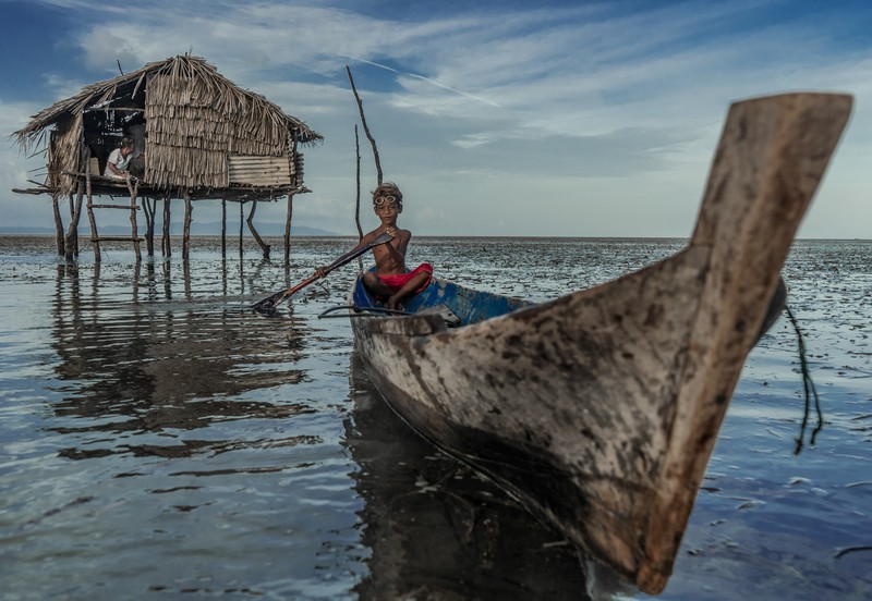 BUTON, SOUTH EAST SULAWESI, INDONESIA - 2020/10/01: Dimas Saputra (10 years old) is seen posing with his favorite boat right in front of his house.
The life of the Bajo tribe, from birth to adulthood, is dependent on the sea. Everything is done there, from looking for food to all life activities carried out in the sea. Dimas Saputra is one of the many children who became an accomplished bajo child with extraordinary diving skills at a young age. Since childhood, his father Muhammad Ajran (36 years old) and his mother Sunarti (35 years old) have been accustomed to knowing and uniting with nature. (Photo by Andry Denisah/SOPA Images/LightRocket via Getty Images)