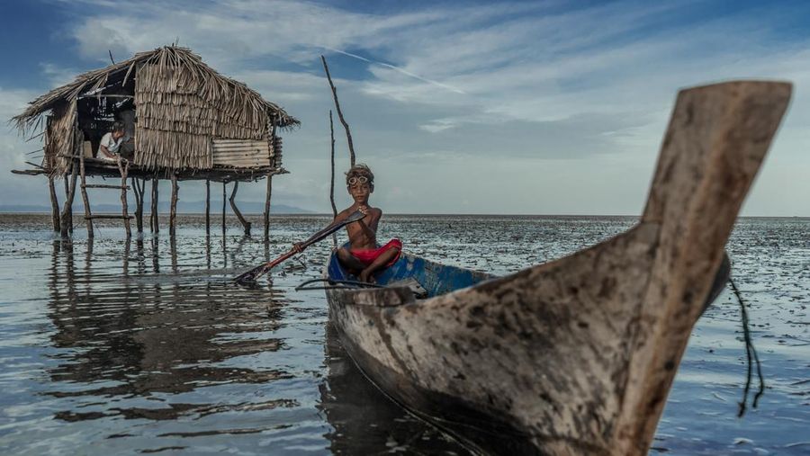BUTON, SOUTH EAST SULAWESI, INDONESIA - 2020/10/01: Dimas Saputra (10 years old) is seen posing with his favorite boat right in front of his house.
The life of the Bajo tribe, from birth to adulthood, is dependent on the sea. Everything is done there, from looking for food to all life activities carried out in the sea. Dimas Saputra is one of the many children who became an accomplished bajo child with extraordinary diving skills at a young age. Since childhood, his father Muhammad Ajran (36 years old) and his mother Sunarti (35 years old) have been accustomed to knowing and uniting with nature. (Photo by Andry Denisah/SOPA Images/LightRocket via Getty Images)