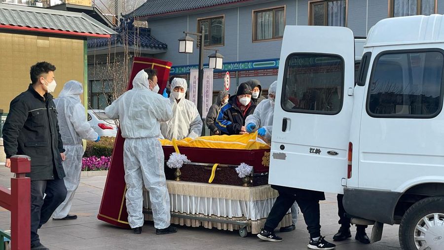 Pengemudi ambulans menurunkan pasien di luar klinik demam yang merawat pasien COVID-19 di Beijing, China, Rabu (21/12/2022). Kondisi pandemi Covid-19 di China terus memburuk seiring dengan berakhirnya kebijakan penguncian ketat di seluruh negeri. (Photo by Kevin Frayer/Getty Images)