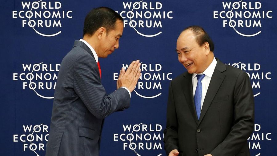 Perdana Menteri Vietnam Nguyen Xuan Phuc (kanan) menyapa Presiden Indonesia Joko Widodo saat tiba untuk sesi pembukaan World Economic Forum on ASEAN di National Convention Center di Hanoi pada 12 September 2018. (Dok. File - BULLIT MARQUEZ/AFP via Getty Images)