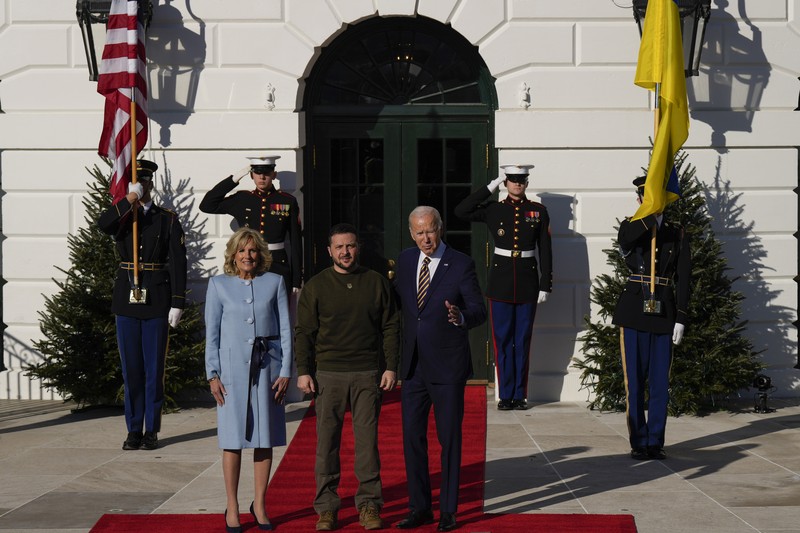 Presiden Joe Biden (Tengah) dan ibu negara Jill Biden menyambut Presiden Ukraina Volodymyr Zelensky di Gedung Putih pada 21 Desember 2022 di Washington, DC. Zelensky bertemu dengan Presiden Biden dalam perjalanan pertamanya yang diketahui ke luar Ukraina sejak invasi Rusia dimulai, dan kedua pemimpin diperkirakan akan membahas bantuan militer yang berkelanjutan. Zelensky dilaporkan akan berpidato di pertemuan gabungan Kongres di malam hari. (Alex Wong/Getty Images)