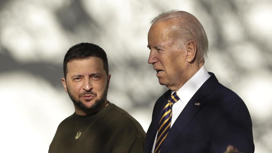 Presiden AS Joe Biden (kanan) dan Presiden Ukraina Volodymyr Zelensky berjalan menyusuri barisan tiang saat mereka menuju Oval Office di Gedung Putih pada 21 Desember 2022 di Washington, DC. Zelensky bertemu dengan Presiden Biden dalam perjalanan pertamanya ke luar Ukraina sejak invasi Rusia dimulai, dan kedua pemimpin diperkirakan akan membahas bantuan militer yang berkelanjutan. Zelensky dilaporkan akan berpidato di pertemuan gabungan Kongres di malam hari. (Alex Wong/Getty Images)
