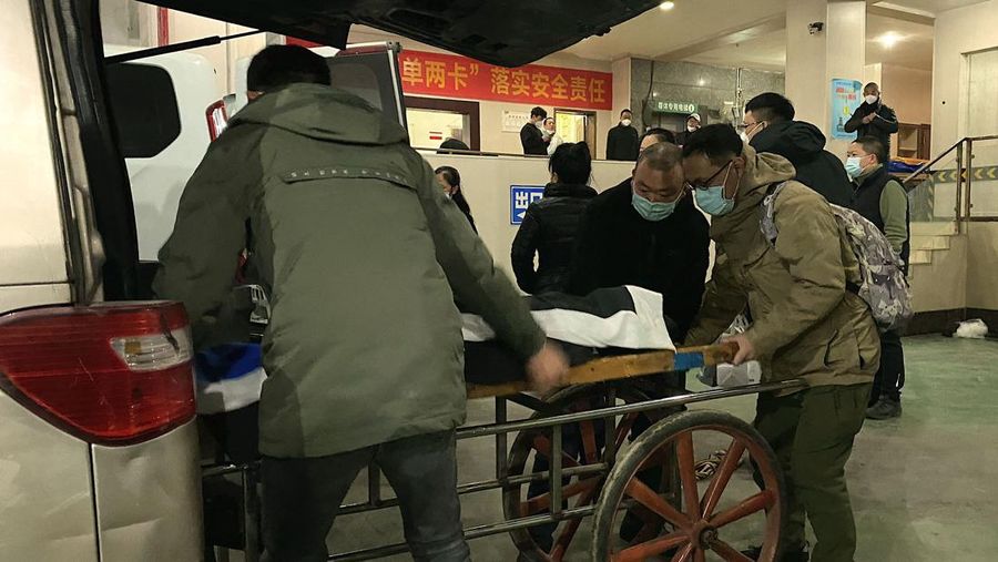 Seorang pekerja pemakaman memasukkan jenazah ke gerobak untuk dikremasi di krematorium di kota Chongqing, China barat daya, pada 22 Desember 2022. (NOEL CELIS/AFP via Getty Images)