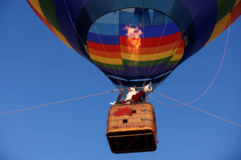Issa Kassissieh dressed as Santa Claus flies above Jerusalem in a hot air balloon December 20, 2022. REUTERS/Amir Cohen