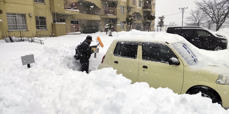 A man clears snow at a parking lot in Kitami, Hokkaido Prefecture, Japan in this photo taken by Kyodo on December 24, 2022.  Mandatory credit Kyodo/via REUTERS ATTENTION EDITORS - THIS IMAGE WAS PROVIDED BY A THIRD PARTY. MANDATORY CREDIT. JAPAN OUT. NO COMMERCIAL OR EDITORIAL SALES IN JAPAN