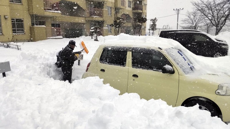 A man clears snow at a parking lot in Kitami, Hokkaido Prefecture, Japan in this photo taken by Kyodo on December 24, 2022.  Mandatory credit Kyodo/via REUTERS ATTENTION EDITORS - THIS IMAGE WAS PROVIDED BY A THIRD PARTY. MANDATORY CREDIT. JAPAN OUT. NO COMMERCIAL OR EDITORIAL SALES IN JAPAN