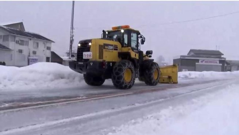 A man clears snow at a parking lot in Kitami, Hokkaido Prefecture, Japan in this photo taken by Kyodo on December 24, 2022.  Mandatory credit Kyodo/via REUTERS ATTENTION EDITORS - THIS IMAGE WAS PROVIDED BY A THIRD PARTY. MANDATORY CREDIT. JAPAN OUT. NO COMMERCIAL OR EDITORIAL SALES IN JAPAN