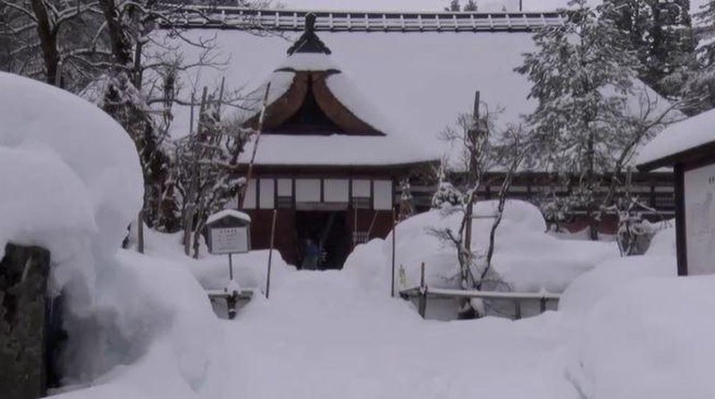 A man clears snow at a parking lot in Kitami, Hokkaido Prefecture, Japan in this photo taken by Kyodo on December 24, 2022.  Mandatory credit Kyodo/via REUTERS ATTENTION EDITORS - THIS IMAGE WAS PROVIDED BY A THIRD PARTY. MANDATORY CREDIT. JAPAN OUT. NO COMMERCIAL OR EDITORIAL SALES IN JAPAN