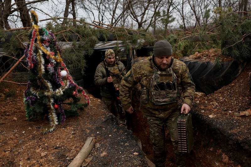 Prajurit Ukraina dengan resimen Polisi Patroli Tugas Khusus Dnipro-1 Raphael Karapitian 45, membawa pohon Natal yang dihias ke parit di garis depan, saat serangan Rusia terhadap Ukraina berlanjut, pada Malam Natal di Bakhmut, Ukraina, 24 Desember 2022. Prajurit Ukraina dengan resimen Polisi Patroli Tugas Khusus Dnipro-1 Raphael Karapitian 45, membawa pohon Natal yang dihias ke parit di garis depan, saat serangan Rusia terhadap Ukraina berlanjut, pada Malam Natal di Bakhmut, Ukraina, 24 Desember 2022. (REUTERS/Clodagh Kilcoyne)