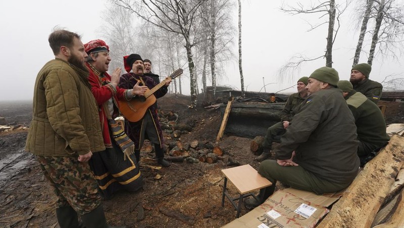 Prajurit Ukraina dengan resimen Polisi Patroli Tugas Khusus Dnipro-1 Raphael Karapitian 45, membawa pohon Natal yang dihias ke parit di garis depan, saat serangan Rusia terhadap Ukraina berlanjut, pada Malam Natal di Bakhmut, Ukraina, 24 Desember 2022. (REUTERS/Clodagh Kilcoyne)