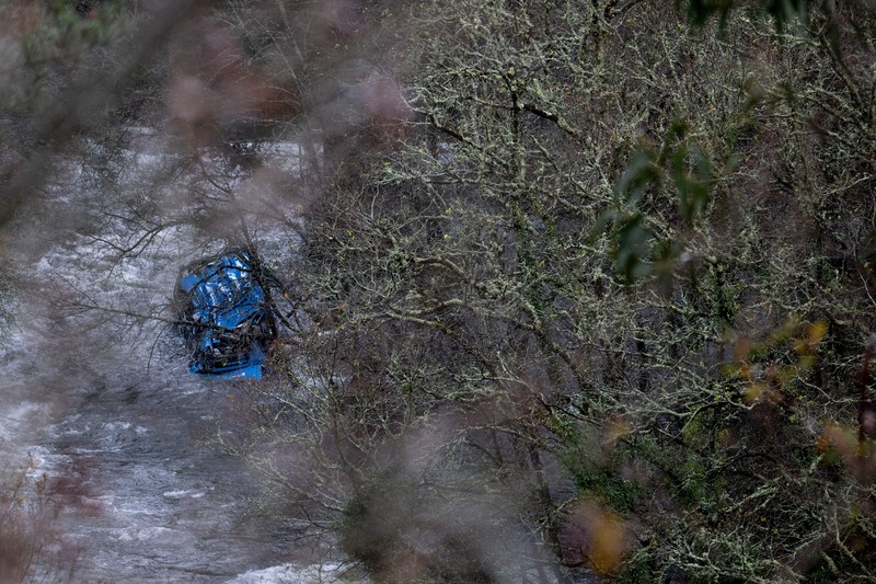 Bangkai bus terletak di sungai Lerez setelah jatuh saat melintasi jembatan, menewaskan empat orang, di Cerdedo-Cotobade, Spanyol barat laut, pada 25 Desember 2022. - Kecelakaan itu terjadi pada 24 Desember malam di dekat Vigo dan perbatasan dengan Portugal. Surat kabar regional La Voz de Galicia mengatakan bus itu membawa orang-orang yang mengunjungi orang yang mereka cintai yang dipenjara di Monterroso di Galicia tengah. Operasi penyelamatan harus dihentikan semalam karena cuaca buruk tetapi dilanjutkan di pagi hari. (BRAIS LORENZO/AFP via Getty Images)