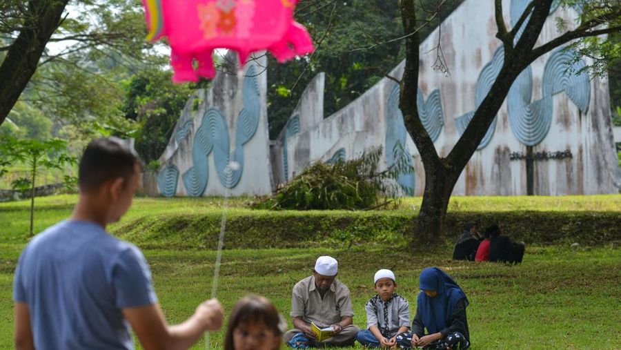 Orang-orang berdoa di kuburan massal di Siron Tsunami Memorial Park di Siron, untuk memperingati 18 tahun tsunami Boxing Day 2004, di provinsi Aceh pada 26 Desember 2022. (CHAIDEER MAHYUDDIN/AFP via Getty Images)