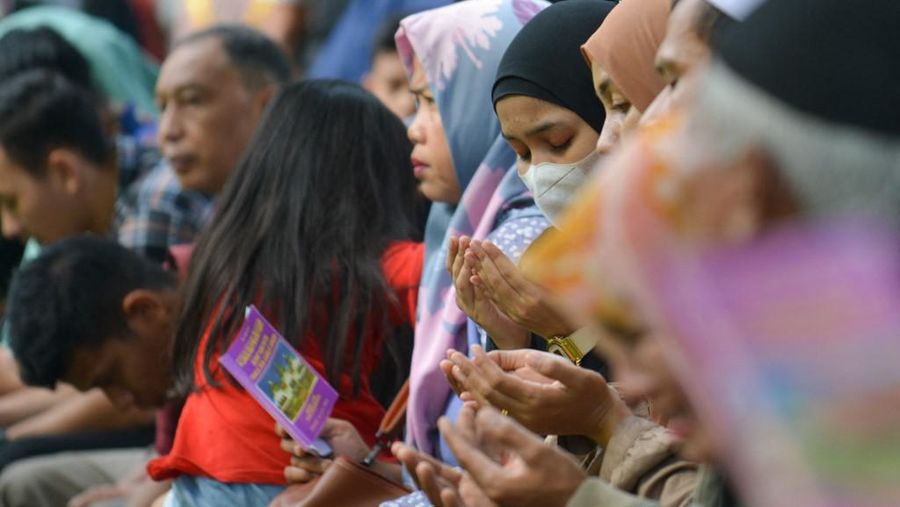 Seorang wanita berdoa di kuburan massal korban untuk memperingati 18 tahun tsunami Boxing Day 2004, di Banda Aceh pada 26 Desember 2022. (PCHAIDEER MAHYUDDIN / AFP)