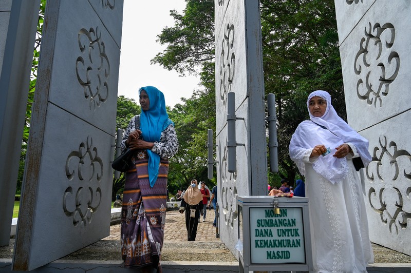 Seorang wanita berdoa di kuburan massal korban untuk memperingati 18 tahun tsunami Boxing Day 2004, di Banda Aceh pada 26 Desember 2022. Seorang wanita berdoa di kuburan massal korban untuk memperingati 18 tahun tsunami Boxing Day 2004, di Banda Aceh pada 26 Desember 2022. (PCHAIDEER MAHYUDDIN / AFP)