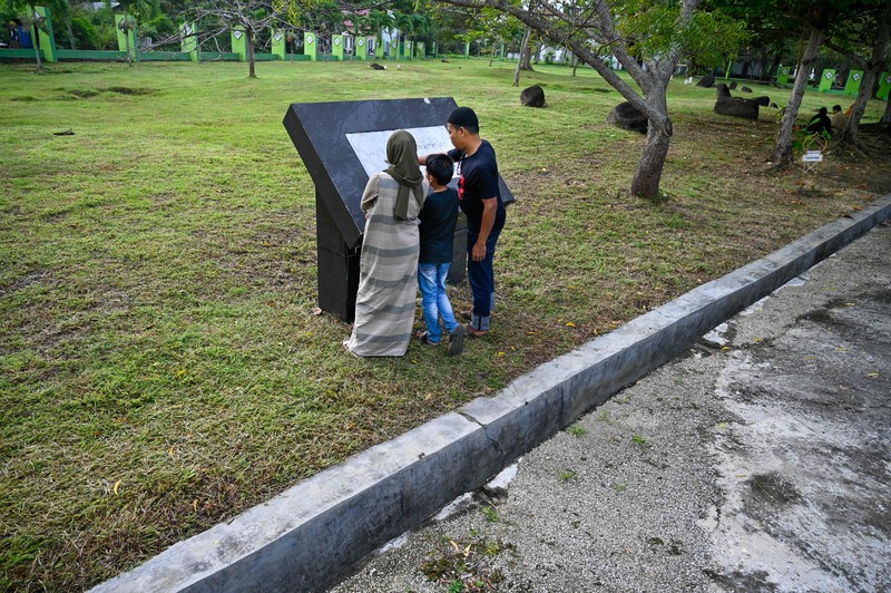 Seorang wanita berdoa di kuburan massal korban untuk memperingati 18 tahun tsunami Boxing Day 2004, di Banda Aceh pada 26 Desember 2022. Seorang wanita berdoa di kuburan massal korban untuk memperingati 18 tahun tsunami Boxing Day 2004, di Banda Aceh pada 26 Desember 2022. (PCHAIDEER MAHYUDDIN / AFP)