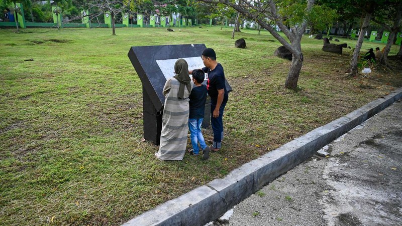 Seorang wanita berdoa di kuburan massal korban untuk memperingati 18 tahun tsunami Boxing Day 2004, di Banda Aceh pada 26 Desember 2022. (PCHAIDEER MAHYUDDIN / AFP)