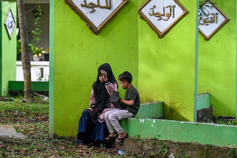 Seorang wanita berdoa di kuburan massal korban untuk memperingati 18 tahun tsunami Boxing Day 2004, di Banda Aceh pada 26 Desember 2022. (PCHAIDEER MAHYUDDIN / AFP)