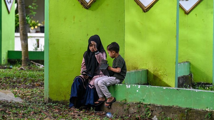 Seorang wanita berdoa di kuburan massal korban untuk memperingati 18 tahun tsunami Boxing Day 2004, di Banda Aceh pada 26 Desember 2022. (PCHAIDEER MAHYUDDIN / AFP)