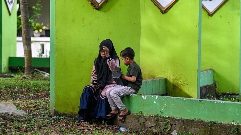 Seorang wanita berdoa di kuburan massal korban untuk memperingati 18 tahun tsunami Boxing Day 2004, di Banda Aceh pada 26 Desember 2022. (PCHAIDEER MAHYUDDIN / AFP)